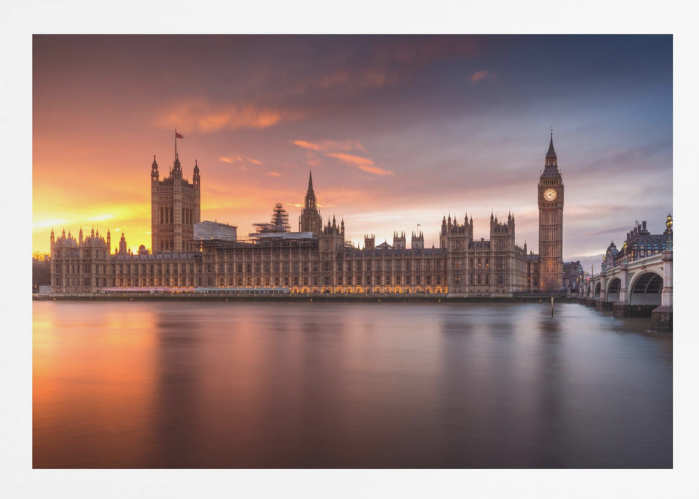 A framed photograph of the Houses of Parliament and Big Ben in London at sunset, with a dramatic orange and purple sky reflecting in the calm waters of the River Thames. Artwork