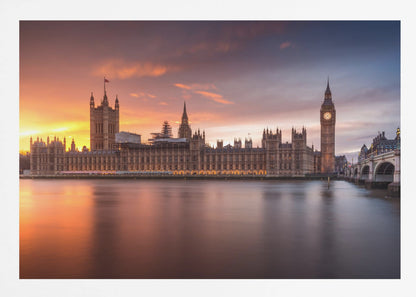 A framed photograph of the Houses of Parliament and Big Ben in London at sunset, with a dramatic orange and purple sky reflecting in the calm waters of the River Thames. Artwork