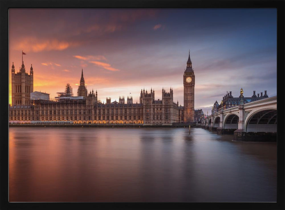 A framed photograph of the Houses of Parliament and Big Ben in London at sunset, with a dramatic orange and purple sky reflecting in the calm waters of the River Thames. Artwork