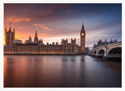 A framed photograph of the Houses of Parliament and Big Ben in London at sunset, with a dramatic orange and purple sky reflecting in the calm waters of the River Thames. Artwork