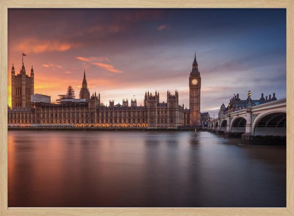 A framed photograph of the Houses of Parliament and Big Ben in London at sunset, with a dramatic orange and purple sky reflecting in the calm waters of the River Thames. Artwork