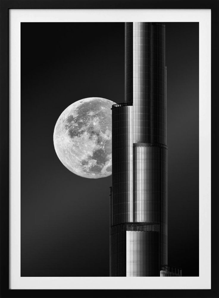 A dramatic black and white photograph of a massive full moon positioned next to a modern, towering skyscraper. The high-contrast image creates a striking juxtaposition between the natural celestial body and the man-made architectural marvel against a dark night sky. Poster