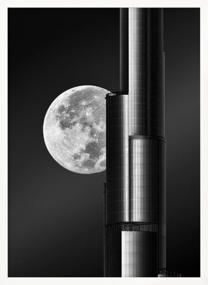 A dramatic black and white photograph of a massive full moon positioned next to a modern, towering skyscraper. The high-contrast image creates a striking juxtaposition between the natural celestial body and the man-made architectural marvel against a dark night sky. Poster
