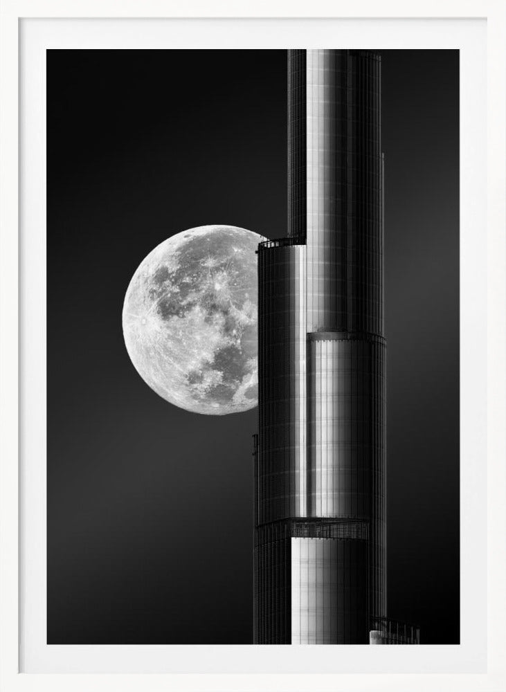 A dramatic black and white photograph of a massive full moon positioned next to a modern, towering skyscraper. The high-contrast image creates a striking juxtaposition between the natural celestial body and the man-made architectural marvel against a dark night sky. Poster
