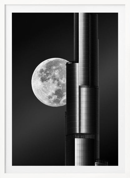 A dramatic black and white photograph of a massive full moon positioned next to a modern, towering skyscraper. The high-contrast image creates a striking juxtaposition between the natural celestial body and the man-made architectural marvel against a dark night sky. Poster