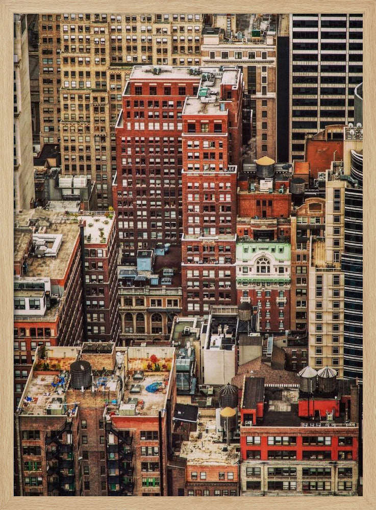 A high-angle, telephoto view of a dense cluster of New York City buildings, featuring a mix of red and brown brick architecture, with numerous windows creating a geometric pattern and several classic wooden water towers perched on the rooftops. Print