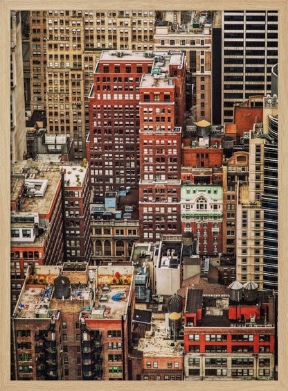 A high-angle, telephoto view of a dense cluster of New York City buildings, featuring a mix of red and brown brick architecture, with numerous windows creating a geometric pattern and several classic wooden water towers perched on the rooftops. Print