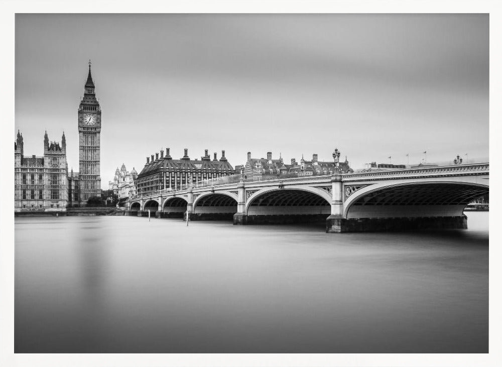 A black and white long-exposure photograph of the Elizabeth Tower (Big Ben) and the Houses of Parliament in London, viewed from across the River Thames. Westminster Bridge stretches across the frame over the smooth, milky water. The image is presented in a silver frame. Artwork