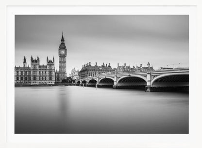 A black and white long-exposure photograph of the Elizabeth Tower (Big Ben) and the Houses of Parliament in London, viewed from across the River Thames. Westminster Bridge stretches across the frame over the smooth, milky water. The image is presented in a silver frame. Artwork