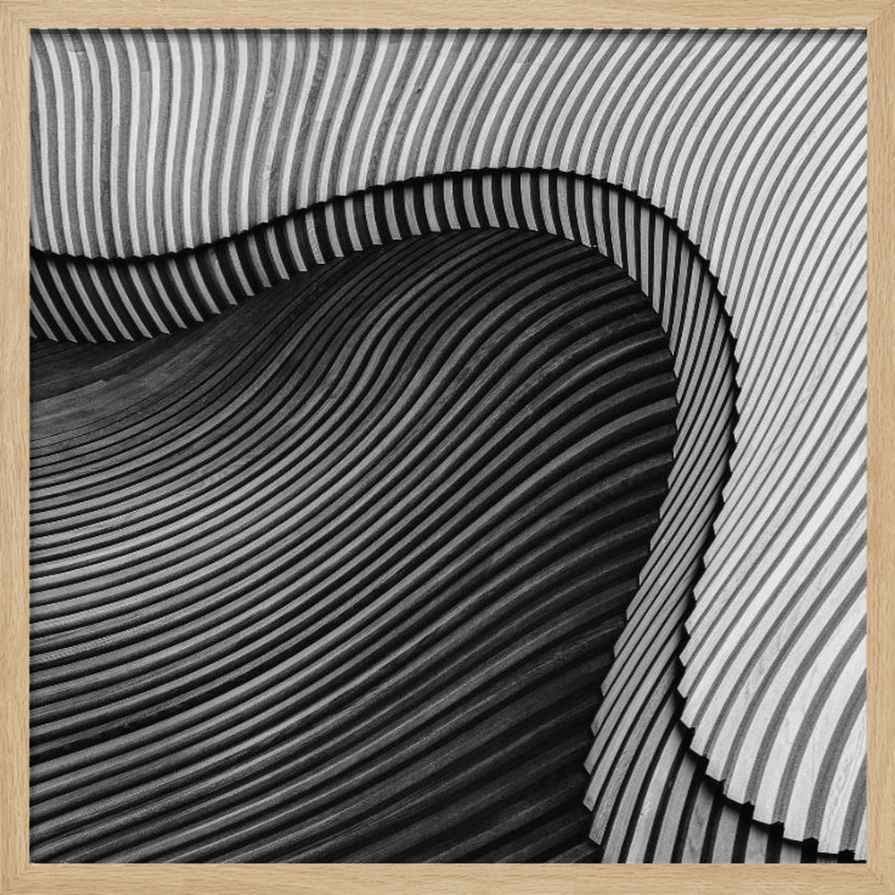 A square, black and white abstract photograph in a light wood frame. The image features layers of flowing, curved surfaces with parallel grooves, creating a strong sense of texture and depth. Lighter, striped layers with vertical lines curve over a darker, undulating section, resembling waves or sculpted wood, drawing the eye into a central dark crevice. Decor