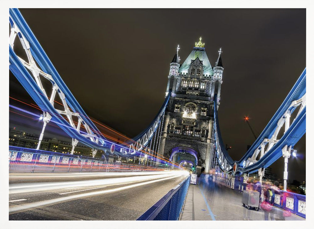 A dramatic, long-exposure night photograph from the deck of London's Tower Bridge, showing vibrant blue support structures curving towards an illuminated stone tower against a dark sky, with bright streaks of light from traffic. Wall Art