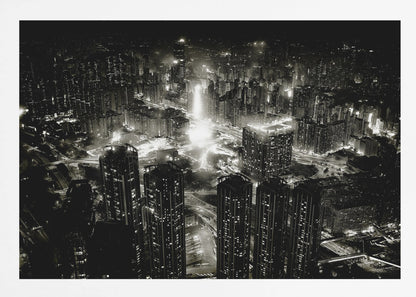 A framed black and white aerial photograph of a dense city at night. The high-angle view captures countless illuminated skyscrapers and winding highways, creating a dramatic and bustling urban landscape. Print