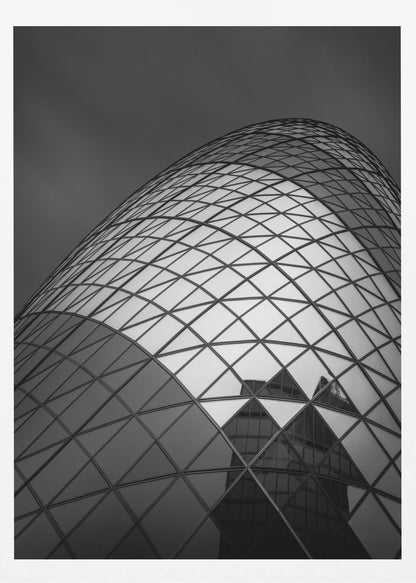 A framed, low-angle, black and white photograph of the curved, glass-paneled facade of a modern skyscraper, creating a dynamic pattern of reflective diamonds against a dark, moody sky. Artwork