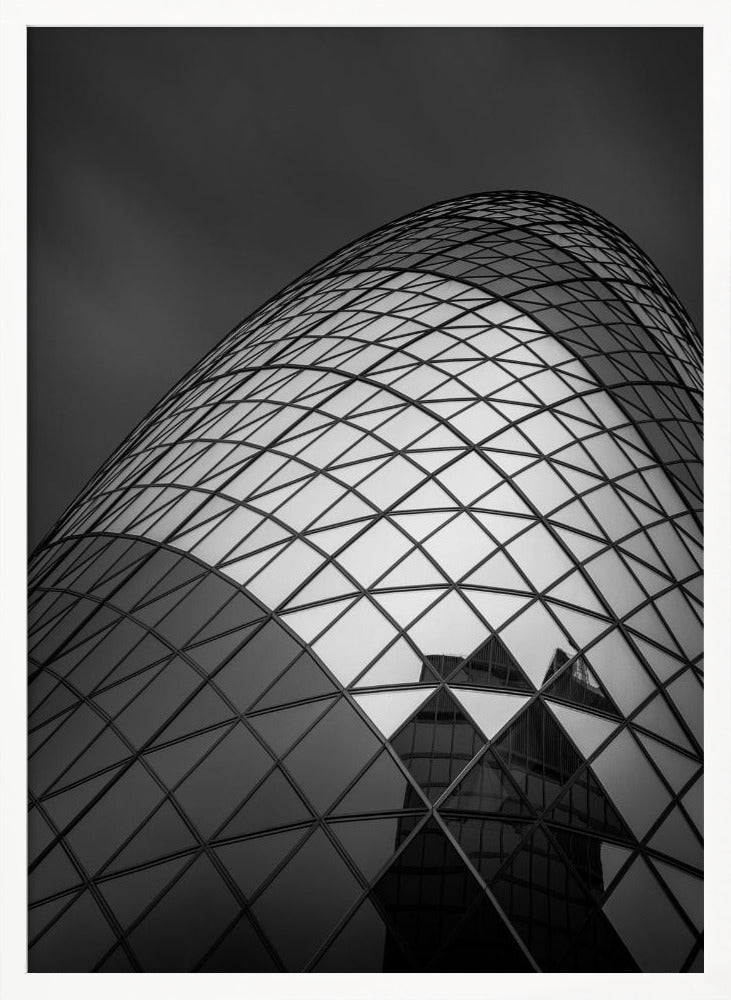 A framed, low-angle, black and white photograph of the curved, glass-paneled facade of a modern skyscraper, creating a dynamic pattern of reflective diamonds against a dark, moody sky. Artwork