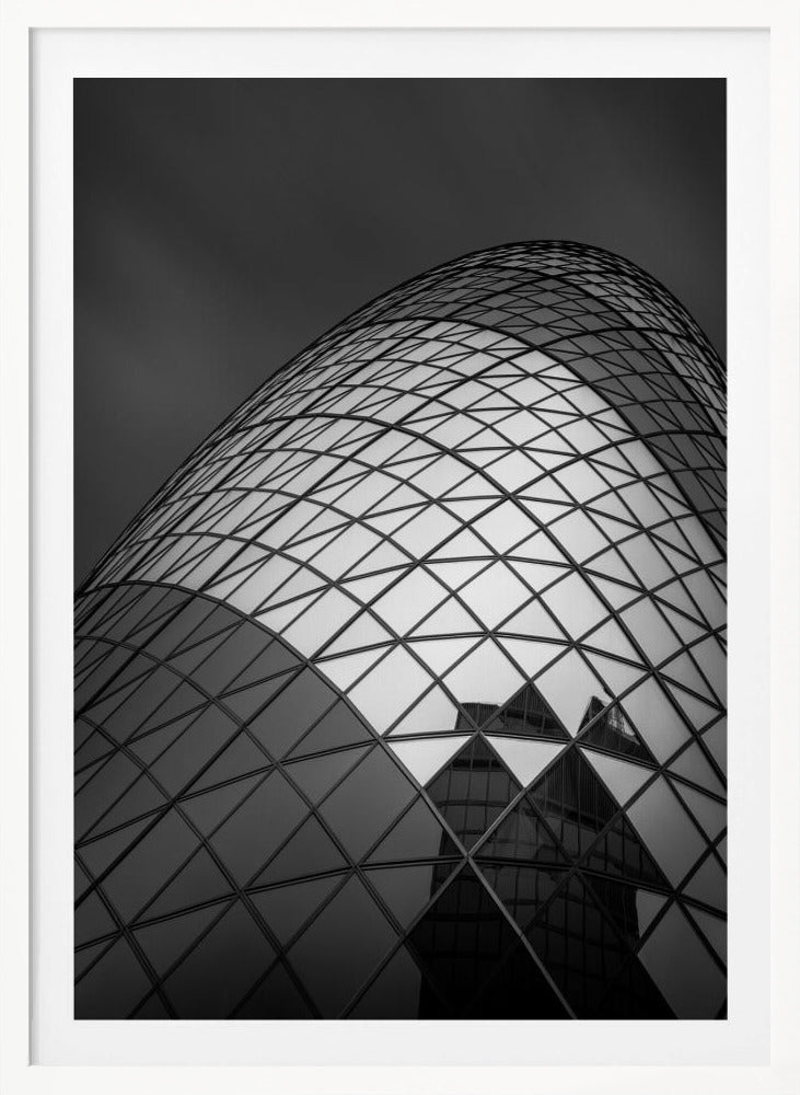 A framed, low-angle, black and white photograph of the curved, glass-paneled facade of a modern skyscraper, creating a dynamic pattern of reflective diamonds against a dark, moody sky. Artwork