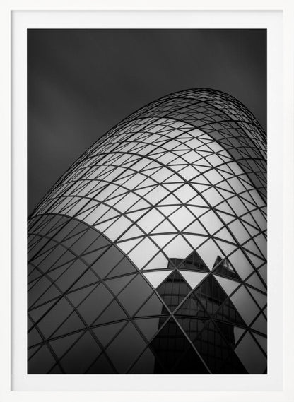 A framed, low-angle, black and white photograph of the curved, glass-paneled facade of a modern skyscraper, creating a dynamic pattern of reflective diamonds against a dark, moody sky. Artwork