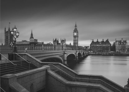A framed, black and white, long-exposure photograph of the London skyline featuring the Houses of Parliament and the Big Ben clock tower across the River Thames. In the foreground, stone steps lead down towards Westminster Bridge, and the water of the river is smooth and reflective under a dark, cloudy sky. Print
