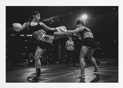 A dramatic black and white action photograph of two female kickboxers in a ring. One fighter, airborne, executes a high kick that connects with the other fighter's gloves, who is bracing for the impact. A referee stands in the background under bright arena lights. Poster