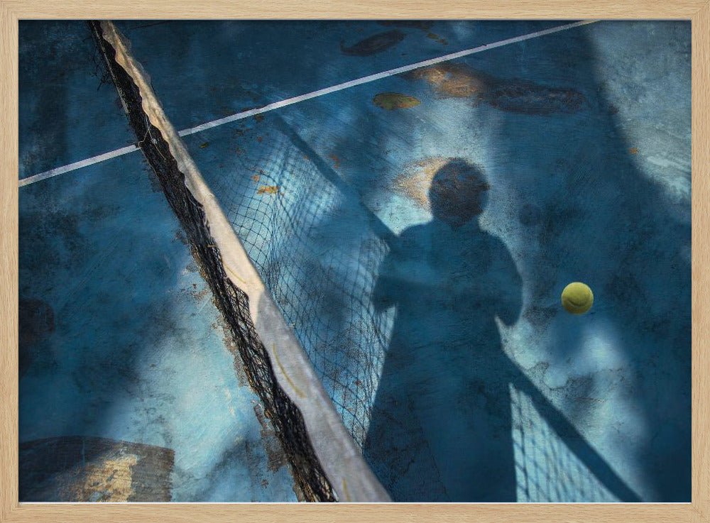 An artistic, high-angle shot of a weathered blue tennis court. The shadow of a tennis player holding a racket is cast across the court, with a yellow tennis ball suspended in mid-air nearby. A tattered tennis net runs diagonally across the frame, all enclosed within a silver border. Wall Art
