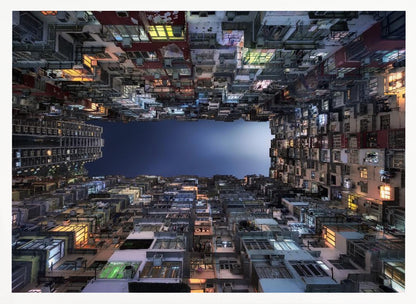 A striking low-angle photograph looking up from a narrow courtyard at the night sky, completely framed by towering, densely packed, and weathered apartment buildings with glowing windows, creating a sense of urban enclosure. Decor
