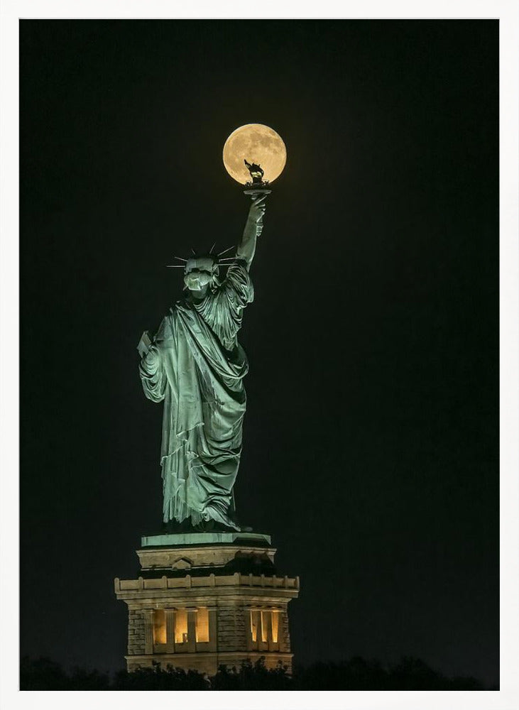 A striking night photograph of the Statue of Liberty, where a large, full yellow moon is perfectly aligned behind the torch, creating the illusion that the statue is holding up the moon. Artwork