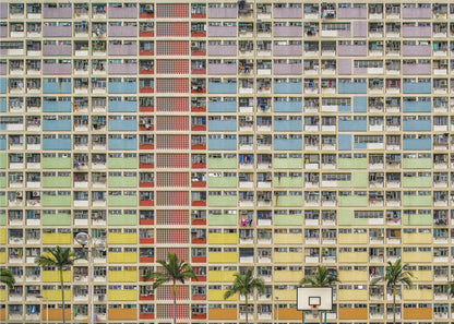 A symmetrical, frontal photograph of the colorful Choi Hung Estate in Hong Kong, featuring a massive grid of apartments with balconies painted in a rainbow of pastel colors including purple, blue, green, yellow, and orange. Palm trees and a basketball court are visible at the base of the building, which is enclosed in a silver frame. Wall Art