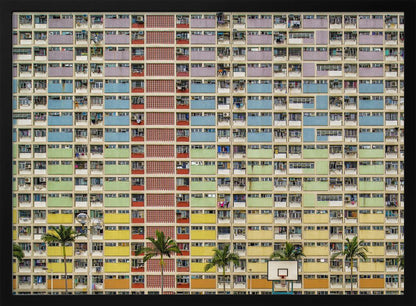 A symmetrical, frontal photograph of the colorful Choi Hung Estate in Hong Kong, featuring a massive grid of apartments with balconies painted in a rainbow of pastel colors including purple, blue, green, yellow, and orange. Palm trees and a basketball court are visible at the base of the building, which is enclosed in a silver frame. Wall Art