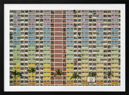 A symmetrical, frontal photograph of the colorful Choi Hung Estate in Hong Kong, featuring a massive grid of apartments with balconies painted in a rainbow of pastel colors including purple, blue, green, yellow, and orange. Palm trees and a basketball court are visible at the base of the building, which is enclosed in a silver frame. Wall Art