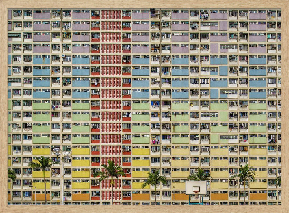 A symmetrical, frontal photograph of the colorful Choi Hung Estate in Hong Kong, featuring a massive grid of apartments with balconies painted in a rainbow of pastel colors including purple, blue, green, yellow, and orange. Palm trees and a basketball court are visible at the base of the building, which is enclosed in a silver frame. Wall Art
