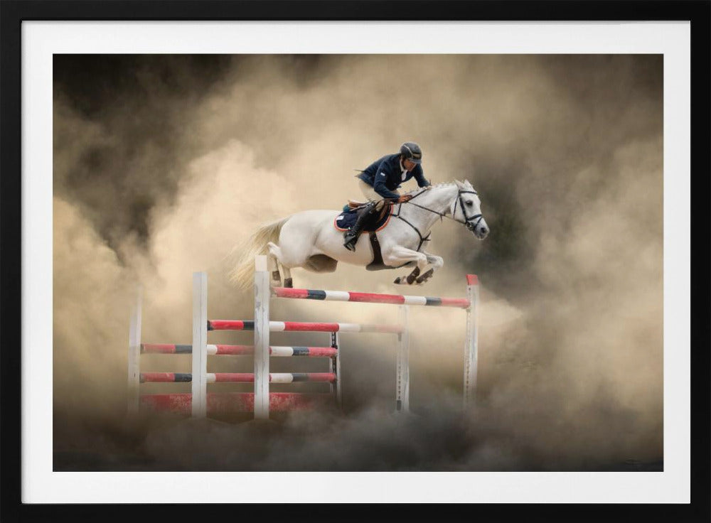 A dramatic action shot of a person in a blue jacket and helmet riding a powerful white horse as it leaps over a red and white striped obstacle, all enveloped in a swirling cloud of brown dust. Print