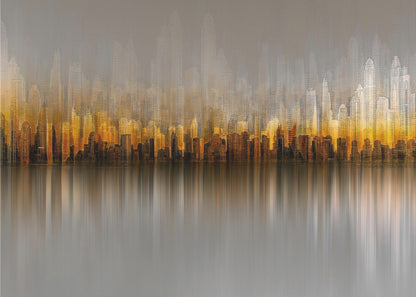 An abstract painting of a city skyline at sunset or sunrise, with buildings glowing in shades of gold, orange, and brown. The hazy, gray sky shows faint outlines of taller buildings in the background. The city is reflected in the water below, with the colors stretched into long, vertical streaks that blend into the gray foreground. The entire piece is enclosed in a simple silver frame. Wall Art