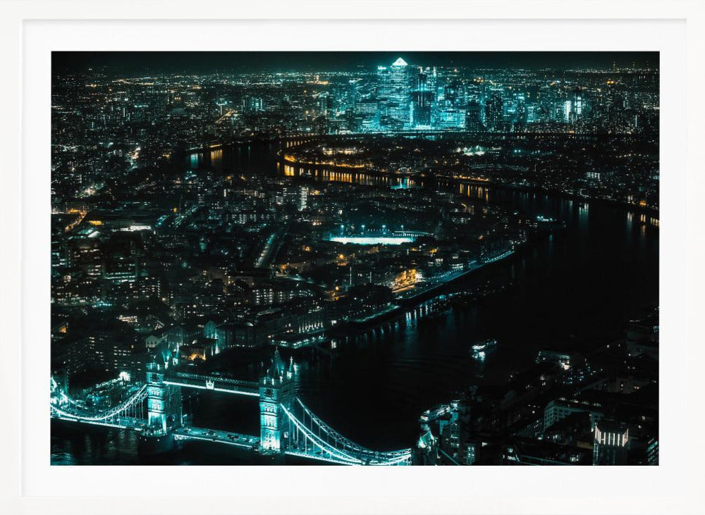 A framed aerial photograph of London at night, featuring the iconic Tower Bridge illuminated in bright teal in the foreground and the glowing skyscrapers of Canary Wharf across the River Thames in the background. Artwork