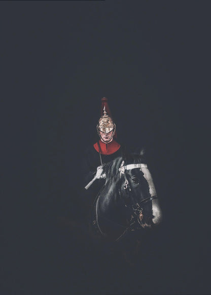 A dramatic portrait of a British Royal Guard on a black horse, emerging from a completely black background. The guard is wearing a traditional uniform with a red collar and a shiny gold helmet with a red plume. Poster