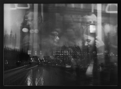 A moody black and white double exposure photograph showing a rainy London street at night with Big Ben, overlaid with the faint reflections of people inside a moving vehicle like a bus. The image has a dreamy, layered effect and is displayed in a silver frame. Print