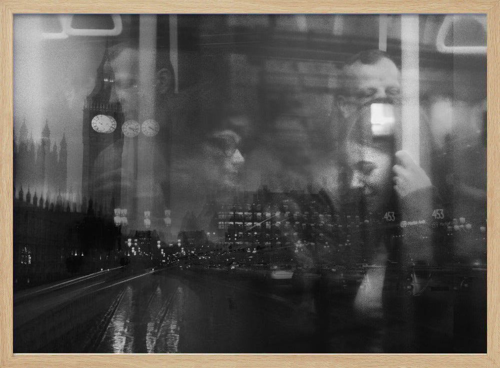 A moody black and white double exposure photograph showing a rainy London street at night with Big Ben, overlaid with the faint reflections of people inside a moving vehicle like a bus. The image has a dreamy, layered effect and is displayed in a silver frame. Print