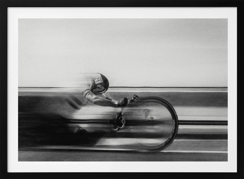 A black and white photograph captured with motion blur, showing a cyclist in an aerodynamic position racing at high speed. The background is blurred into horizontal lines, emphasizing the velocity. The image is enclosed in a silver frame. Wall Art