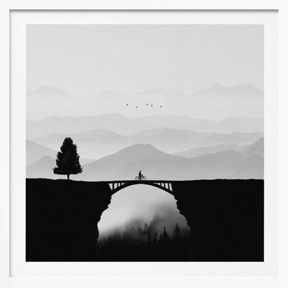 A minimalist black and white artwork featuring the silhouette of a cyclist crossing a high arched bridge between two cliffs. A lone tree stands on one cliff, while layers of misty mountains fill the background, creating a sense of depth and solitude. Poster