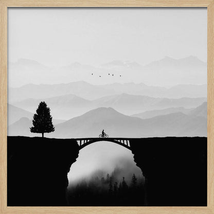 A minimalist black and white artwork featuring the silhouette of a cyclist crossing a high arched bridge between two cliffs. A lone tree stands on one cliff, while layers of misty mountains fill the background, creating a sense of depth and solitude. Poster