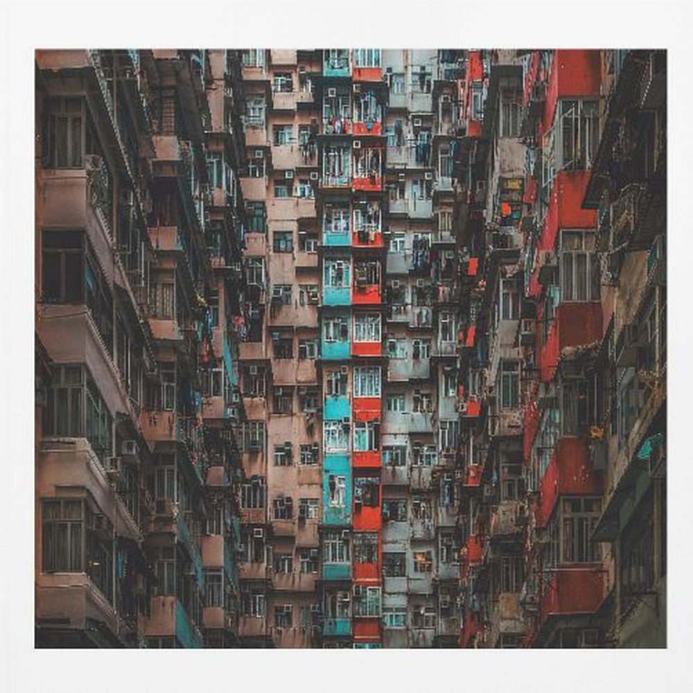 A framed, low-angle photograph looking up at densely packed, weathered apartment buildings that create a canyon-like view, with some facades painted in vibrant red and teal. Wall Art