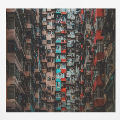 A framed, low-angle photograph looking up at densely packed, weathered apartment buildings that create a canyon-like view, with some facades painted in vibrant red and teal. Wall Art