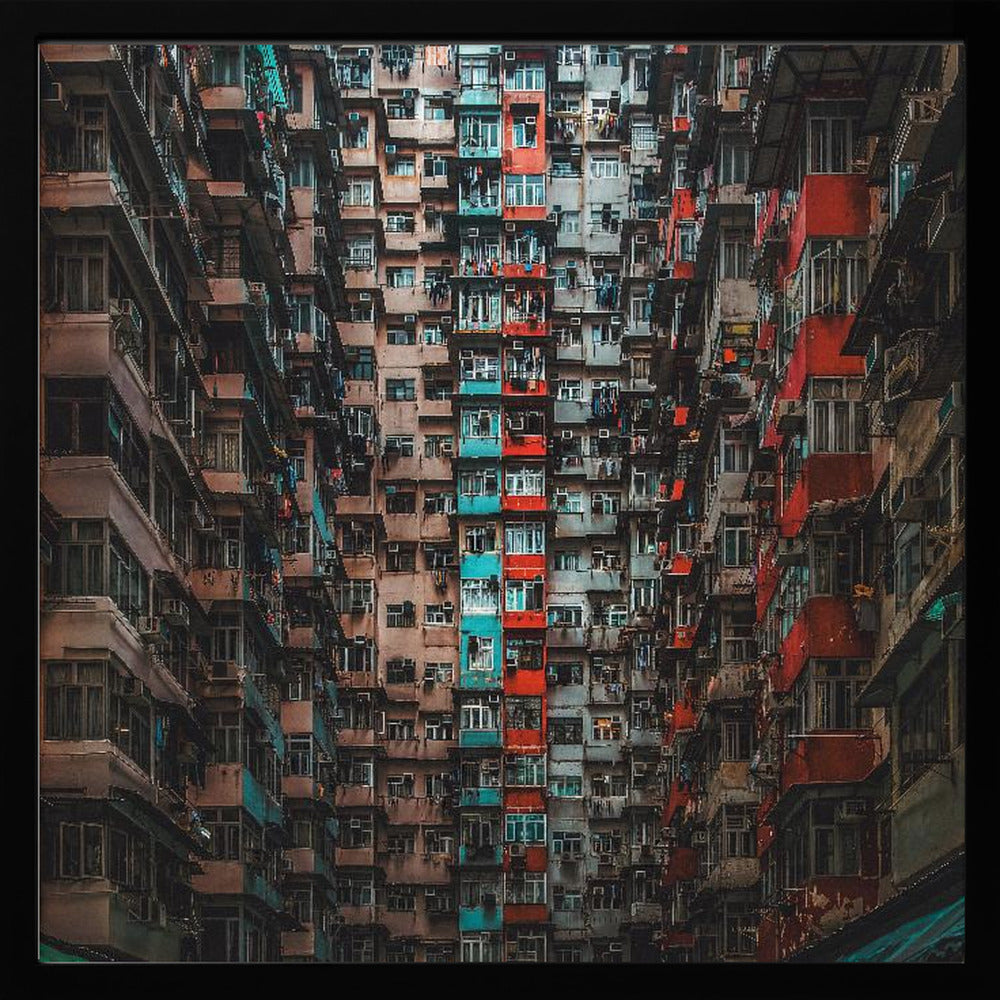 A framed, low-angle photograph looking up at densely packed, weathered apartment buildings that create a canyon-like view, with some facades painted in vibrant red and teal. Wall Art