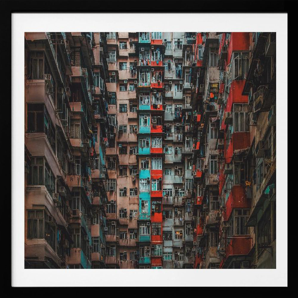 A framed, low-angle photograph looking up at densely packed, weathered apartment buildings that create a canyon-like view, with some facades painted in vibrant red and teal. Wall Art