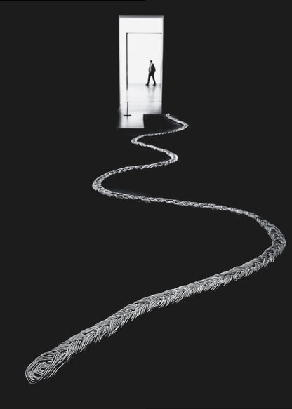 A high-contrast, black and white photograph of a thick, silver, braided rope winding across a black floor, leading towards a brightly lit doorway in the distance where a silhouetted man is walking away. Wall Art