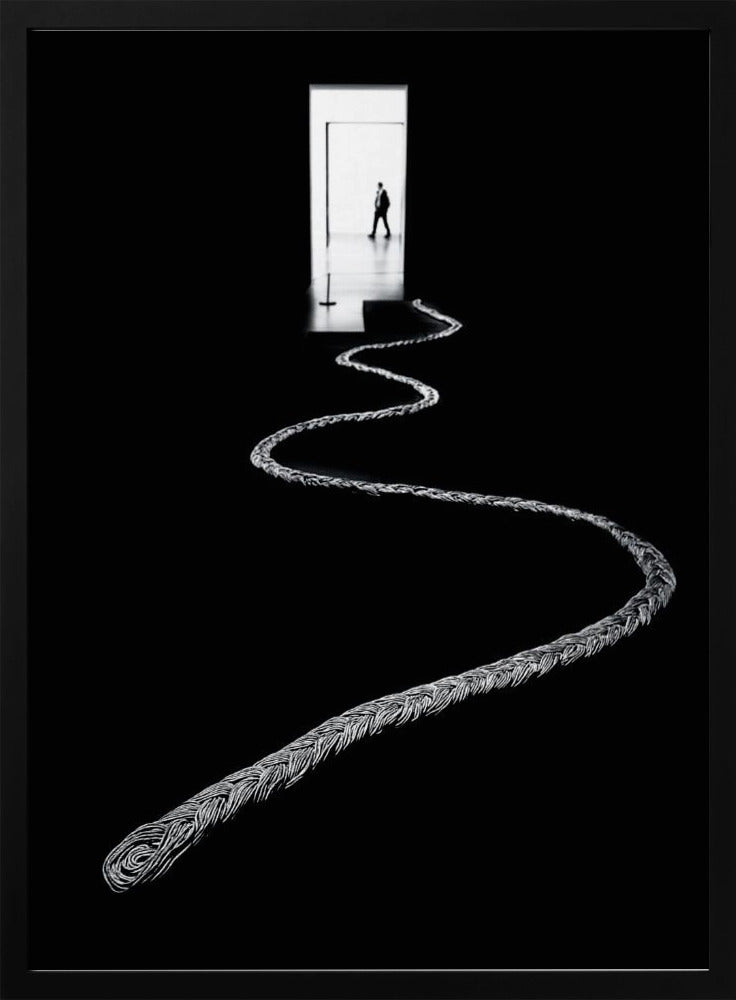 A high-contrast, black and white photograph of a thick, silver, braided rope winding across a black floor, leading towards a brightly lit doorway in the distance where a silhouetted man is walking away. Wall Art