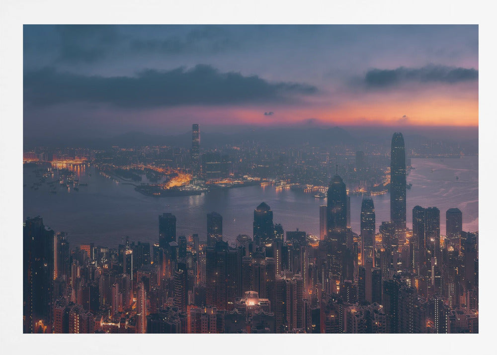 An aerial photograph of a sprawling city skyline at dusk, likely Hong Kong, with countless illuminated skyscrapers. The sky above transitions from a warm orange glow at the horizon to a deep purple, with dark clouds overhead. The city lights cast a golden reflection on the water of the harbor. The entire image is presented within a silver-colored frame. Poster