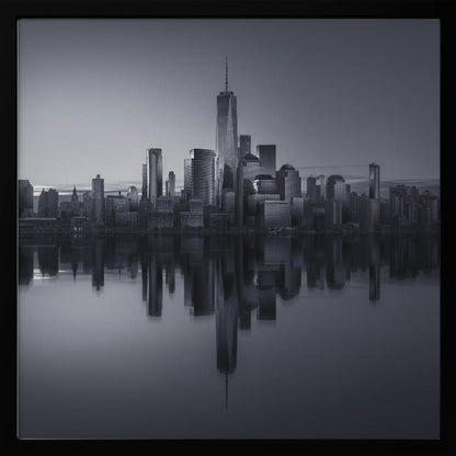 A framed, moody black and white photograph of the Lower Manhattan skyline, featuring the One World Trade Center, with a perfect, still reflection of the skyscrapers in the water below. Decor