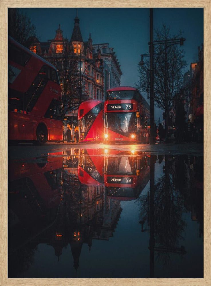 A moody, low-angle photograph of a wet London street at dusk, with a vibrant red double-decker bus reflected perfectly in a large puddle in the foreground. Print