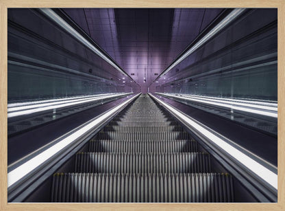 A symmetrical, first-person view looking down a long, empty escalator in a modern subway station, with bright white lights lining the handrails and a purple glow on the ceiling, creating a futuristic and infinite perspective. Wall Art