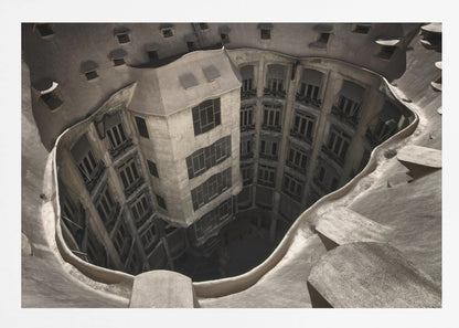 A surreal, high-angle photograph looking down into the distorted, cavernous courtyard of a building. The walls and windows appear to melt and curve inwards towards a dark void, creating a powerful optical illusion. The image has a muted, sepia-toned color palette and is presented in a silver frame. Wall Art