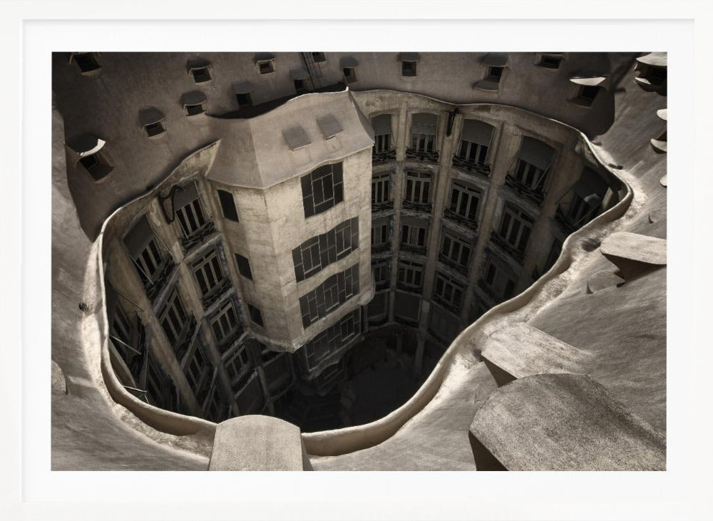 A surreal, high-angle photograph looking down into the distorted, cavernous courtyard of a building. The walls and windows appear to melt and curve inwards towards a dark void, creating a powerful optical illusion. The image has a muted, sepia-toned color palette and is presented in a silver frame. Wall Art